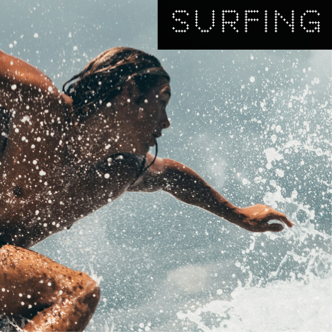 A person surfing on a wave with water splashing around, with the word 'SURFING' in capital letters in the top right corner