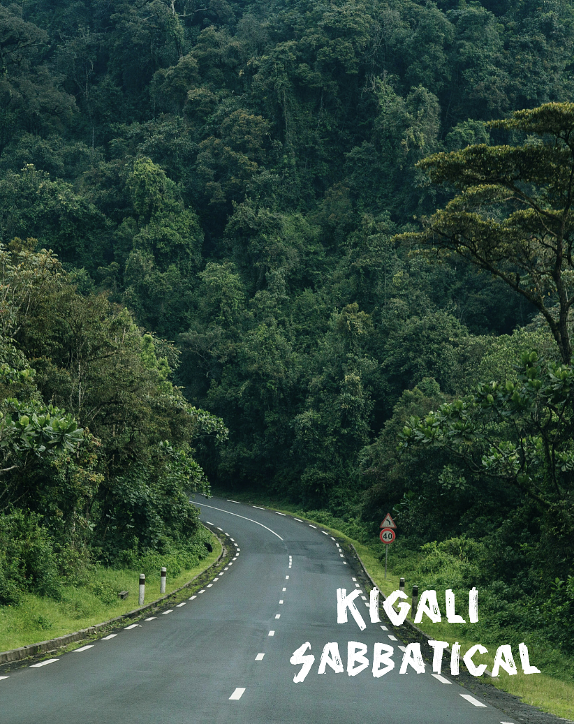 A winding paved road through a dense green forest with a traffic sign indicating a speed limit of 40, and the words "Kigali Sabbatical" written in white text at the bottom right corner.