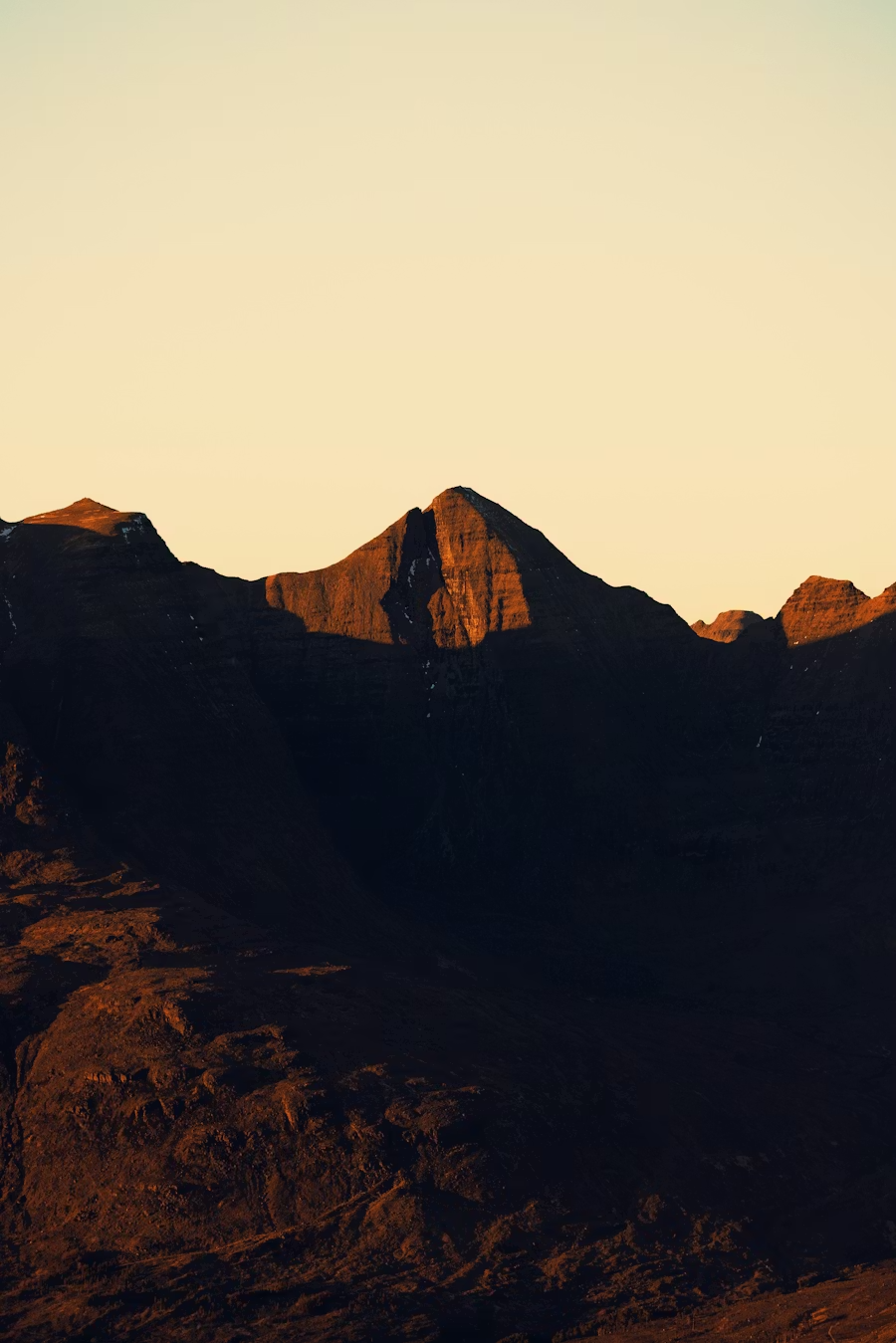 Sunlit mountain peaks at sunset or sunrise with a clear sky